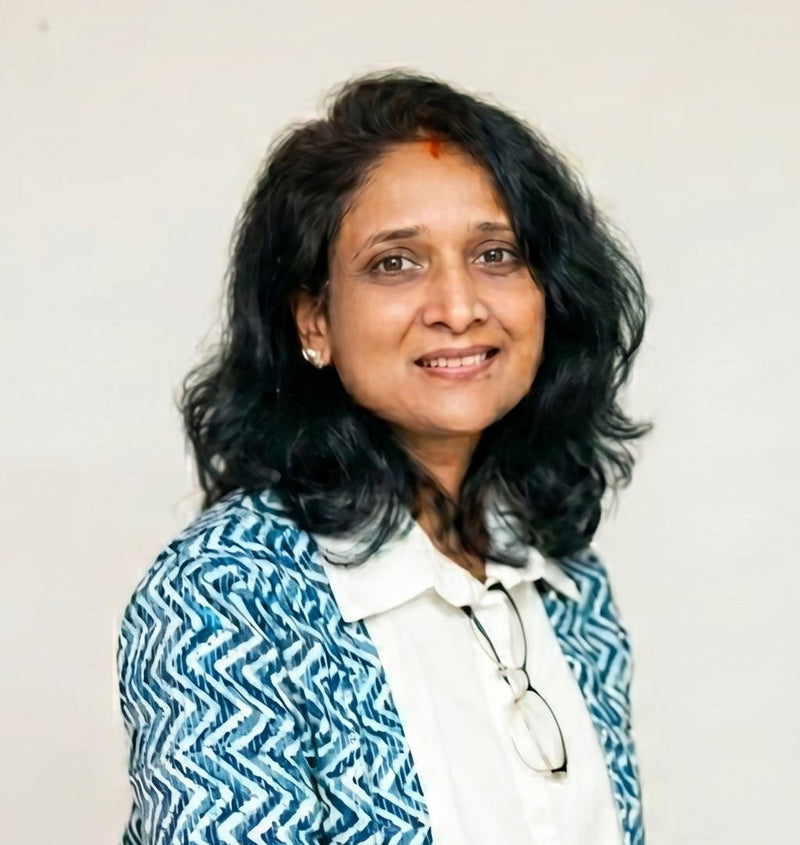 Woman wearing a blue and white patterned jacket with a plain background